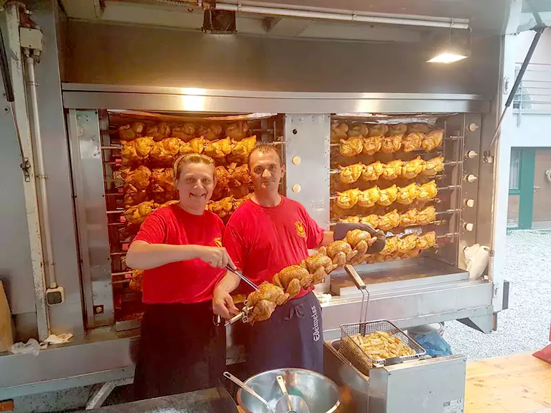 Mann und Frau beim Grillhendl-Imbisswagen